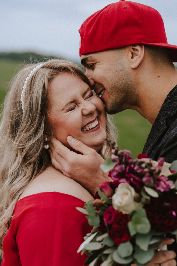 Fotograf Reutlingen Tübingen Hochzeit Paare Brautpaar er küsst sie auf die Wange und sie lacht herzlich in Römerstein