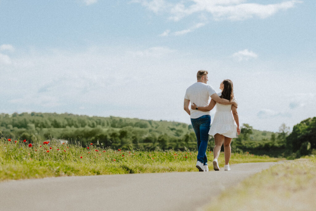 Fotograf Reutlingen Tübingen Hochzeit Paar läuft an einem Mohnblumenfeld entlang und hat Spaß in Tübingen