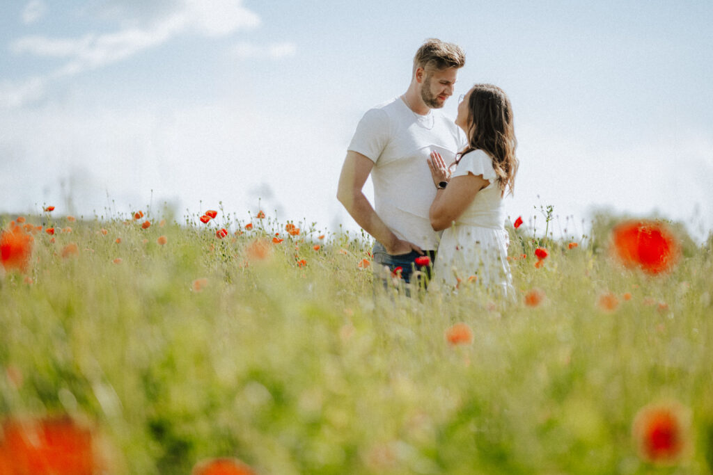 Fotograf Reutlingen Tübingen Hochzeit Paar steht in einem Mohnblumenfeld und schaut sich an in Tübingen