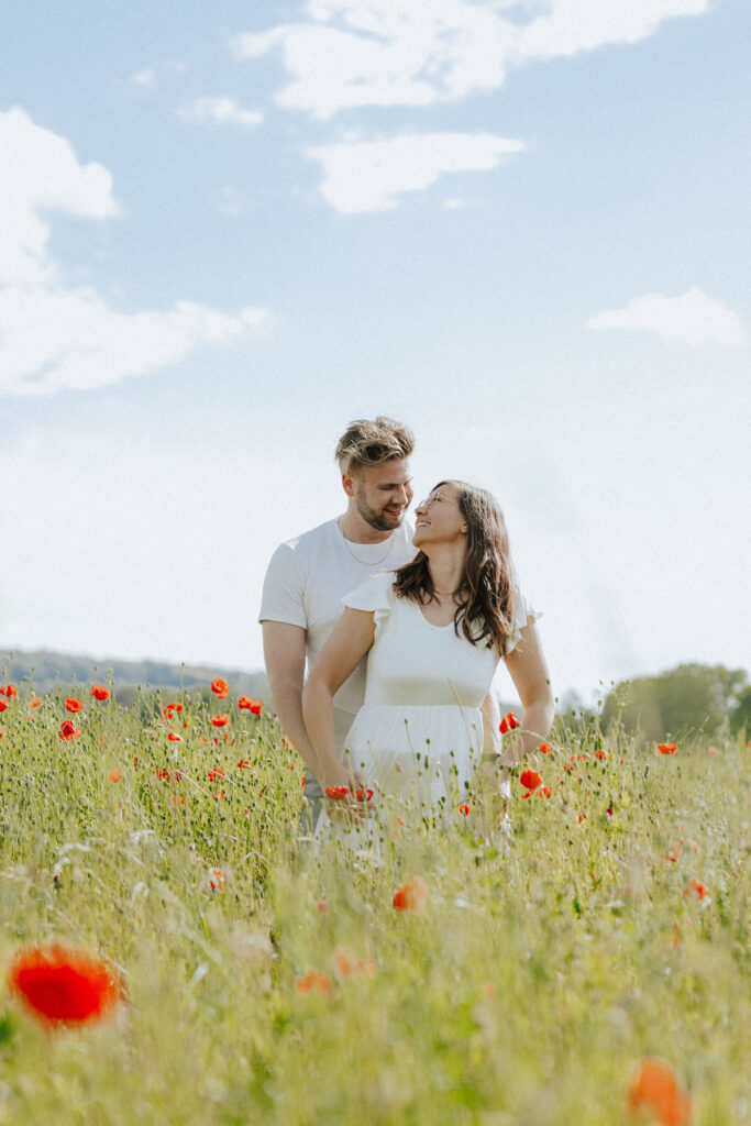 Fotograf Reutlingen Tübingen Hochzeit Paar steht in einem Mohnblumenfeld und sie schauen sich an in Tübingen