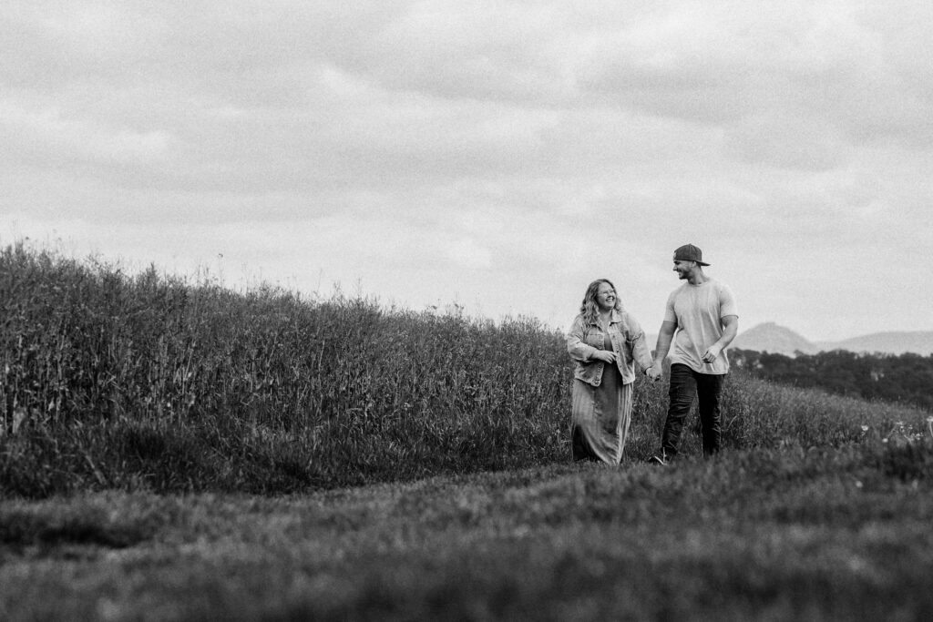 Fotograf Reutlingen Tübingen Hochzeit Paar läuft an einem Rapsfeld entlang und lacht sich an in Pliezhausen