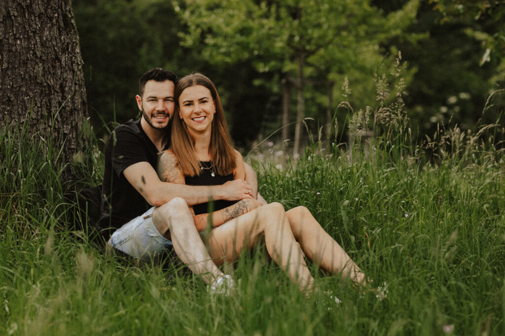 Fotograf Reutlingen Tübingen Hochzeit Paar sitzt vor einander in einer Wiese in Walddorfhäslach