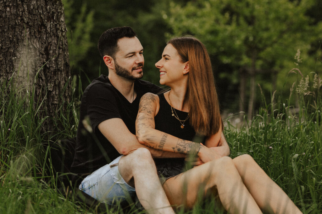 Fotograf Reutlingen Tübingen Hochzeit Paar sitzt vor einander in einer Wiese und sie schauen sich an in Walddorfhäslach