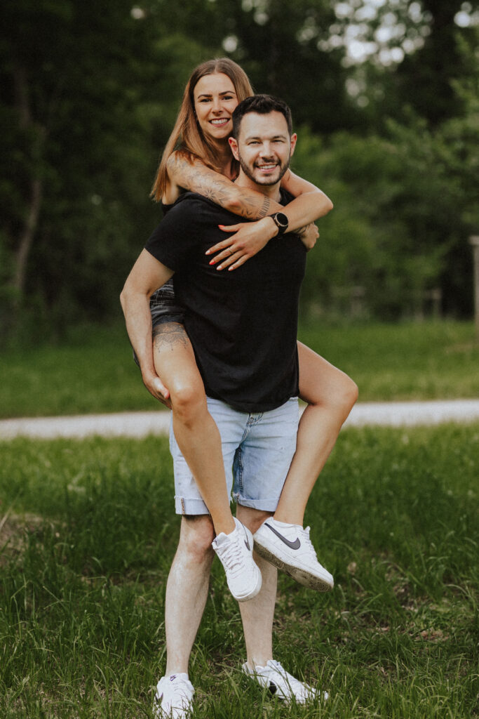 Fotograf Reutlingen Tübingen Hochzeit Paar er trägt sie Huckepack auf einer Wiese in Walddorfhäslach